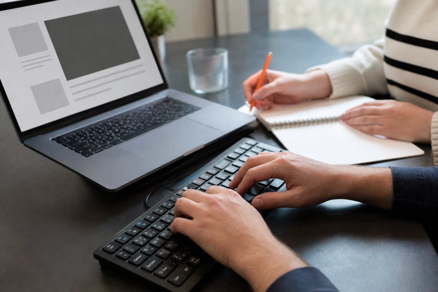 Twee collega's testen een website met toetsenbordbediening en maken aantekeningen